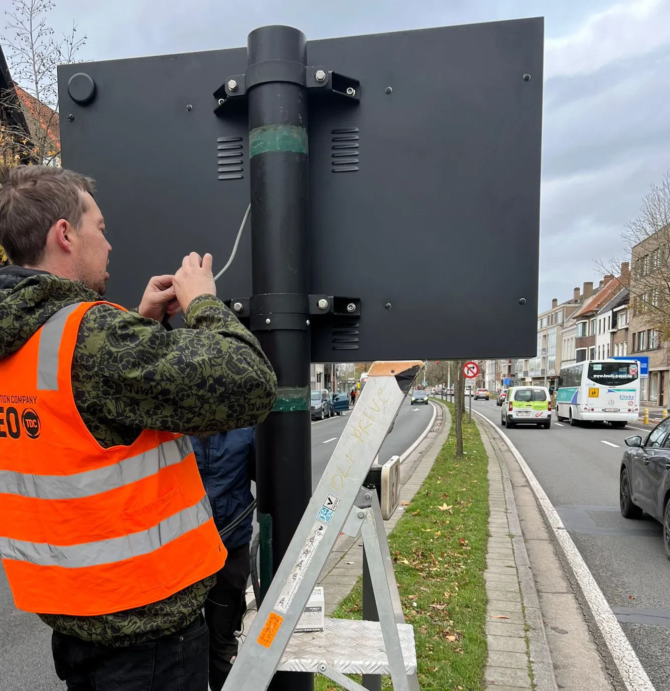 Panneau LED directionnel affichant les informations de parking, avec une équipe en gilets fluorescents