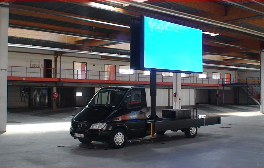 Camion publicitaire mobile avec un écran LED allumé en intérieur, prêt pour des campagnes de communication innovantes et modulables